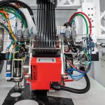 The automated fiber placement head places a component on the laying table in the cell.